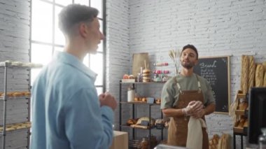 Pastanede iki adam ekmek seçimini tartışırken, önlüklü bir adam kapalı mekan dükkanında hamur işlerini hazırlıyor.