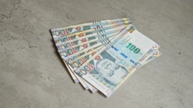 Peru tabanlı banknotlar, Peru 'dan gelen paraların sergilendiği beton bir yüzeye saçıldı..