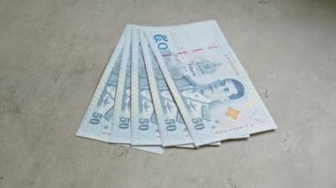 Tayland 'dan 50 baht banknot içeren beton bir yüzeye yerleştirilmiş Tayland banknotları..