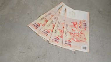 Singapur 'da 10 dolarlık banknotlar somut bir yüzeye yayılmış. Bu da paraların detaylı bir görüntüsünü veriyor..