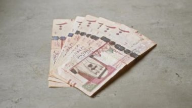 Suudi Arabistan riyal banknotları yığını Orta Doğu para biriminin sergilendiği beton bir yüzey üzerinde