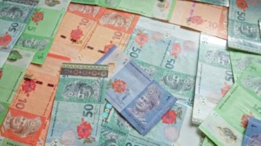 Malezya banknotları çeşitli banknotlar halinde dağılarak, karmaşık tasarımları ve canlı renkleriyle ringgit olarak bilinen Malezya para birimini göstermektedir..