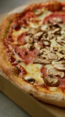 Lezzetli mantar ve erimiş peynir ve domates soslu jambonlu pizza.