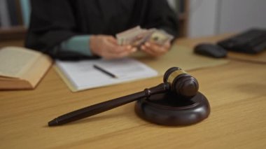 Kadın tokmak yakınında para sayıyor ve açık bir kitap, el, para, yasal ayarlar