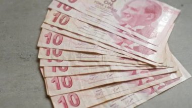 Türk lira banknotları somut bir zemine yayılarak, para birimi değerlerini ve Türkiye 'den gelen tarihi bir figürün portresini gözler önüne seriyor..