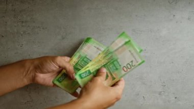 Rus rublesi banknotlarını somut bir zemine karşı sayan kişi, tarafsız bir ortamda para yönetimi eylemini vurguluyor