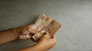 Türk lira banknotlarını somut bir arkaplan karşısında sayan eller, Türkiye 'deki mali işlemler veya zenginlik kavramını vurguluyor