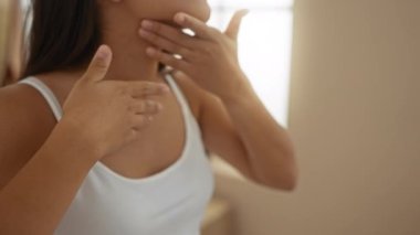 Kaplıcaya cilt bakımı yapan bir kadın, elleri boyunda, sağlık merkezinde kapalı bir odada.