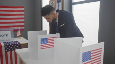 A hispanic man in a suit votes in a room with american flags, symbolizing electoral participation. clipart