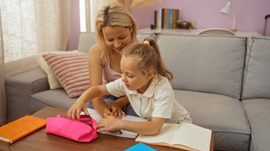 Anne, kızına ev ödevlerinde yardım ediyor.
