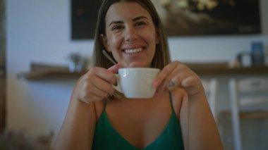 Genç İspanyol kadın sıcak bir gülümsemeyle İtalyan kafeteryasında kahvesini yukarda içiyor..