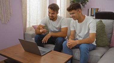 Baba ve oğul evde, oturma odasında, samimi bir ortamda sevgi ve birlikteliği gösteren bir video konferansı yapıyorlar..