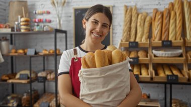 Fırında elinde ekmek tutan kadın gülümsüyor, yetişkin, çekici, esmer, İspanyol, kapalı, dükkan, lezzetli, taze.