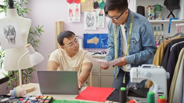 Kumaş, tasarım, dikiş makinesi ve mezura ile bir terzide çalışan iki adam..