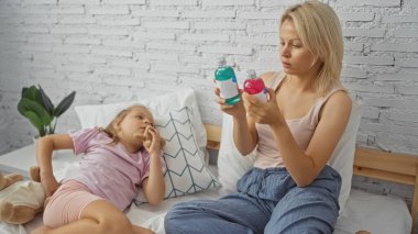 Kadın ve çocuk yatak odasında birlikte, anne iki şişe tutarken kız yanında bir oyuncakla yatıyor, bir aile yaratıyor, kapalı bir sahne.