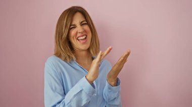 Woman laughing over an isolated pink background, exuding happiness and positivity in a relaxed and playful manner, with blonde hair wearing a blue shirt. clipart