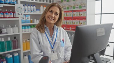 Modern bir eczanede çalışan gülümseyen kadın eczacı. Etrafı ilaç ve sağlık ürünleriyle çevrili..