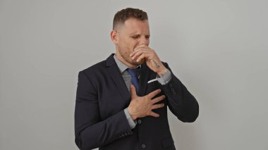 Takım elbiseli yakışıklı adam öksürüyor ya da beyaz arka planda boğuluyor.