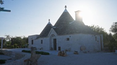 Güneş batarken alberobello, puglia, italyan, açık havada geleneksel mimari sergilenen, karakteristik konik çatıları olan Trullo evi..