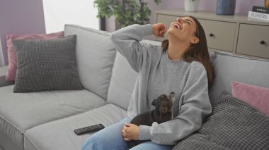 Gülen bir kadın, kapalı bir koltukta Chihuahua 'sıyla eğleniyor.