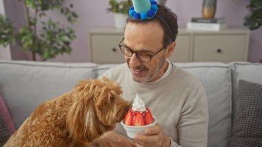 İspanyol adam tatlıyı evde köpekle paylaşıyor, arkadaşlık ve evcil hayvan bakımını resmediyor..