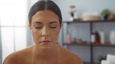 İçerideki bir sağlık merkezinde sakin bir ifadeyle rahatlayan bir kadın spa ortamında güzel bir esmeri sergiliyor.