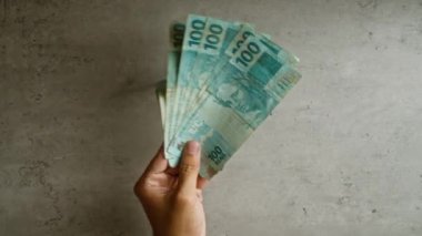Brezilya 'da somut bir arka plana karşı el gösterimi, para, finans, para, para ve ekonomi vurgulanması
