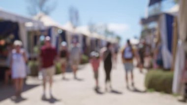 Bulanık insanlar, Mallorca 'da güneşli gökyüzünün altında yürüyorlar. Odaklanmış arka plan ve bokeh etkisine odaklanıyorlar.