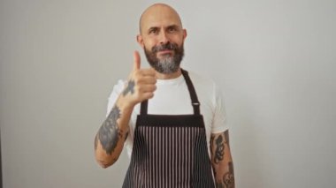 Önlük giymiş kel bir adam mutlu bir şekilde gülümsüyor olumlu onay işareti mükemmel izole edilmiş beyaz arka plan kendinden emin neşeli bir arkadaş portresi