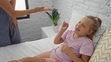 Anne ve kızı yatak odasında birlikte oynuyorlar.