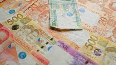 Filipin banknotları 500, 200, 100 ve 20 peso gibi çeşitli banknotlar yayılarak Filipinler 'in canlı para birimini vurguluyor..
