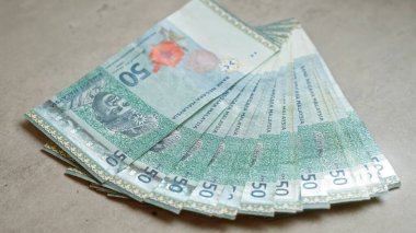 Malezya halka banknotları beton bir yüzeye yayılarak ulusal para birimini ayrıntılı ve iyi aydınlatılmış bir kompozisyonda sergiliyordu..