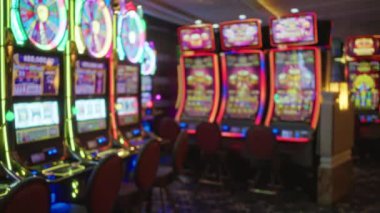 Las Vegas kumarhanesinde parlak neon ışıkları olan bulanık kumar makineleri hareketli, canlı bir ev atmosferi yaratıyor..