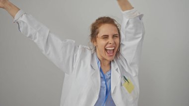 Joyful caucasian female doctor in lab coat celebrating against a white background, portraying success and happiness. clipart