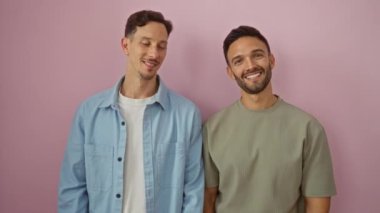 İzole edilmiş pembe arka planda birlikte gülümseyen çift, sevgi ve mutluluk gösteriyor.