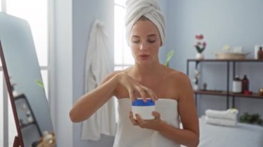 Cilt bakımını seven bir kadın spa sağlık merkezinde kafasına ve vücuduna sarılı bir havluyla kapalı bir odada