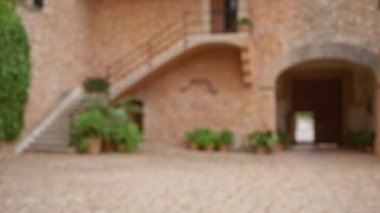 Terracotta duvarları, taş merdivenleri ve yeşil bitkilerle Mallorca 'daki sönük avluda sakin bir açık hava ortamı yaratıyor.