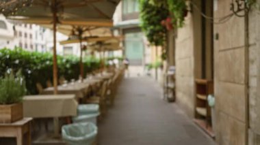 Roma 'nın eski bir kasabasında masaları ve sandalyeleri olan bulanık bir kafenin manzarası. Yumuşak bokeh ışıkları altında dar bir cadde. Yeşillik ve büyüleyici mimariyle çevrili..