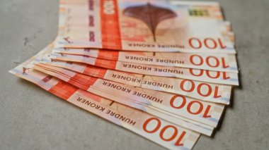 Norveç 100 kron banknotları, Norveç 'te para, para, finans, nakit ve ekonominin altını çizerek somut bir yüzeye yayıldı.