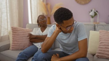 Anne ve oğlu sıcak bir oturma odasında Pastel dekorla ciddi bir tartışma yapıyorlar. Aile bağlarını, duygularını ve ev ortamını ön plana çıkarıyorlar.