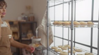 Fırında yemek organize ederken telefonda konuşan bir kadın önlük takıyor.