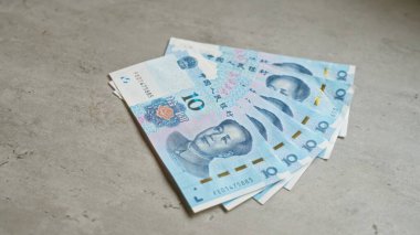 Çin Yuan banknotları, Çin 'in para birimi ve ekonomik unsurlarının altını çizerek somut bir yüzeye yerleştirildi..