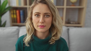 Güzel, genç, sarışın bir kadının portresi. Rastgele giyinmiş, evde oturuyor ve iç mimarisi rahat..