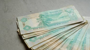Birleşik Arap Emirlikleri Merkez Bankası 'nın 10 dirhem para birimini gösteren somut bir yüzey üzerindeki Uae banknotları, yerel para ve mali bağlamları vurguluyor.