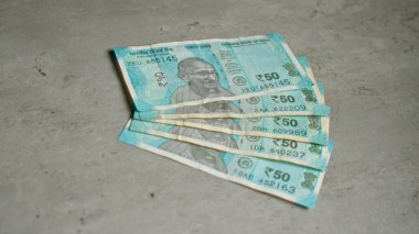 Hindistan banknotları somut bir yüzey üzerinde sergileniyor. 50 rupilik banknotlar finansal tema oluşturuyor..
