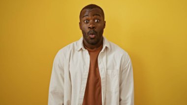 Genç, Afrikalı, Amerikalı, izole edilmiş sarı bir arka plana karşı duran bir adam.