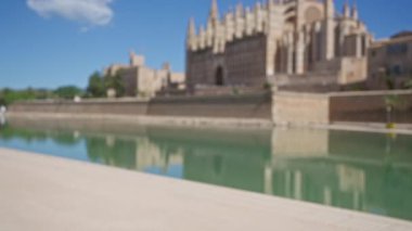 Palma katedralinin bulanık görüntüsü Mallorca İspanya 'da açık hava arka planında berrak mavi gökyüzünün altındaki suya yansıyor.