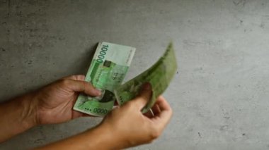 Kore parası sayan adam beton duvar arkaplanı, altını çizen eller ve yeşil para notları ile kazandı..