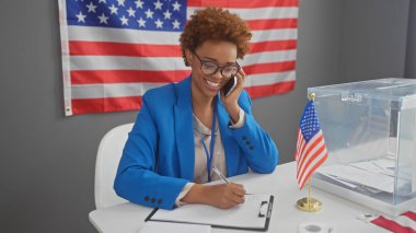 A smiling african american woman in a blue blazer taking notes in a room with an american flag clipart