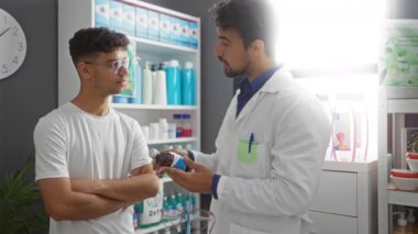 Eczacı, modern bir eczane odasında çeşitli sağlık ürünleriyle dolu genç bir erkek hastaya ilacı açıklıyor.